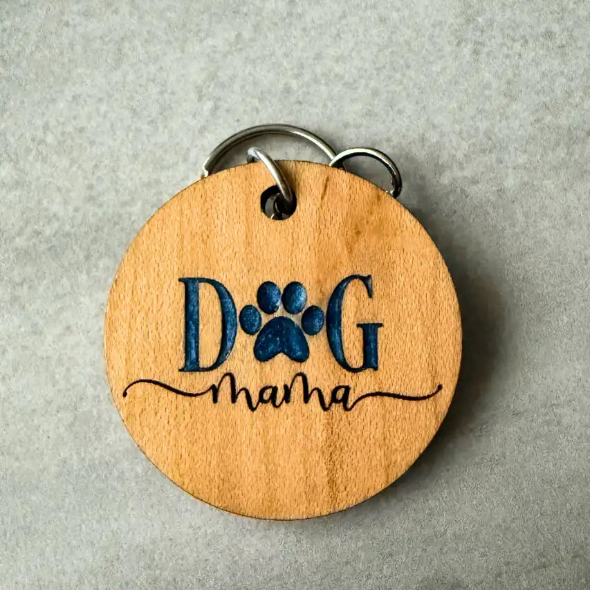 Wooden keychain with 'Dog Mama' engraving on a gray background