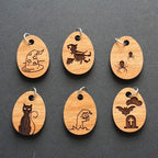Set of six wooden charms with Halloween-themed designs on a dark gray background.