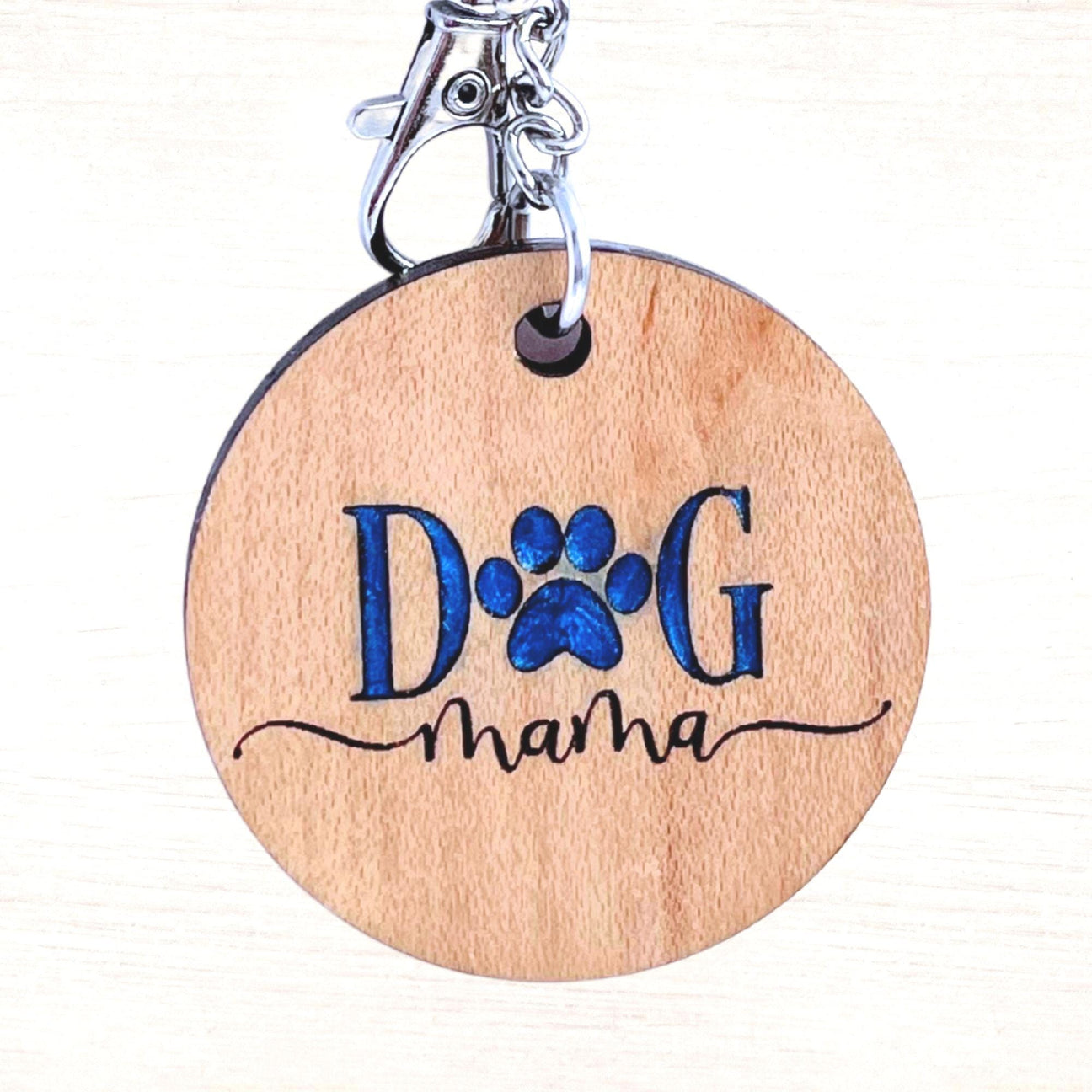 Close up of dog mama keychain with blue resin inlay on a silver keyring.