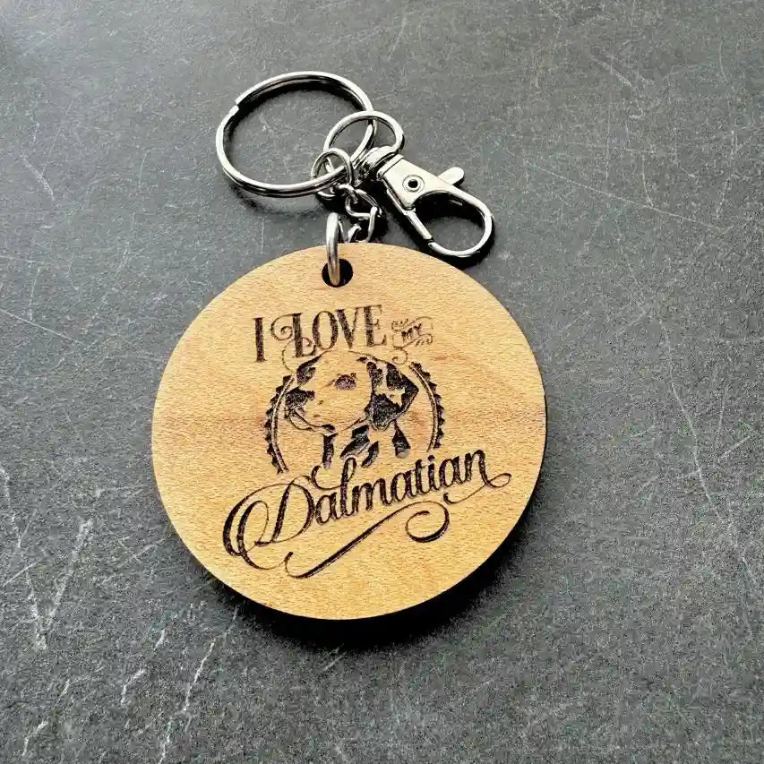 Wooden keychain with 'I Love Dalmatian' engraving on a gray surface