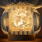 Decorative lamp with floral fairy cutout design on a dark background