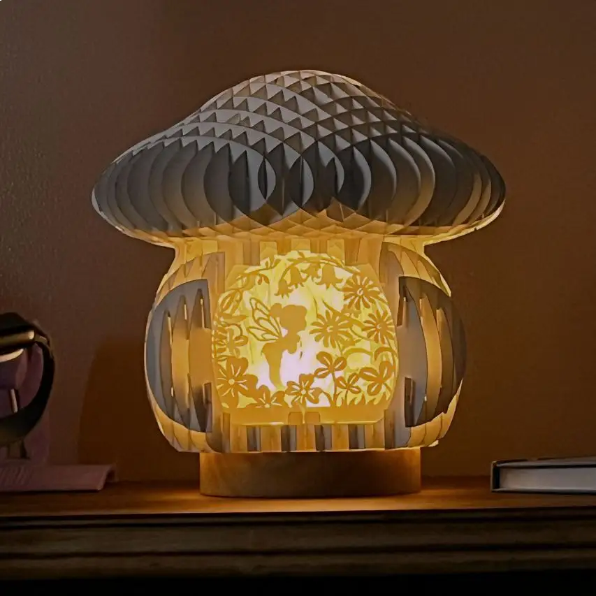 Mushroom-shaped lamp with fairy scene  on a wooden surface.