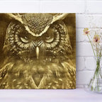 Owl engraving on a white brick wall with a vase of flowers.